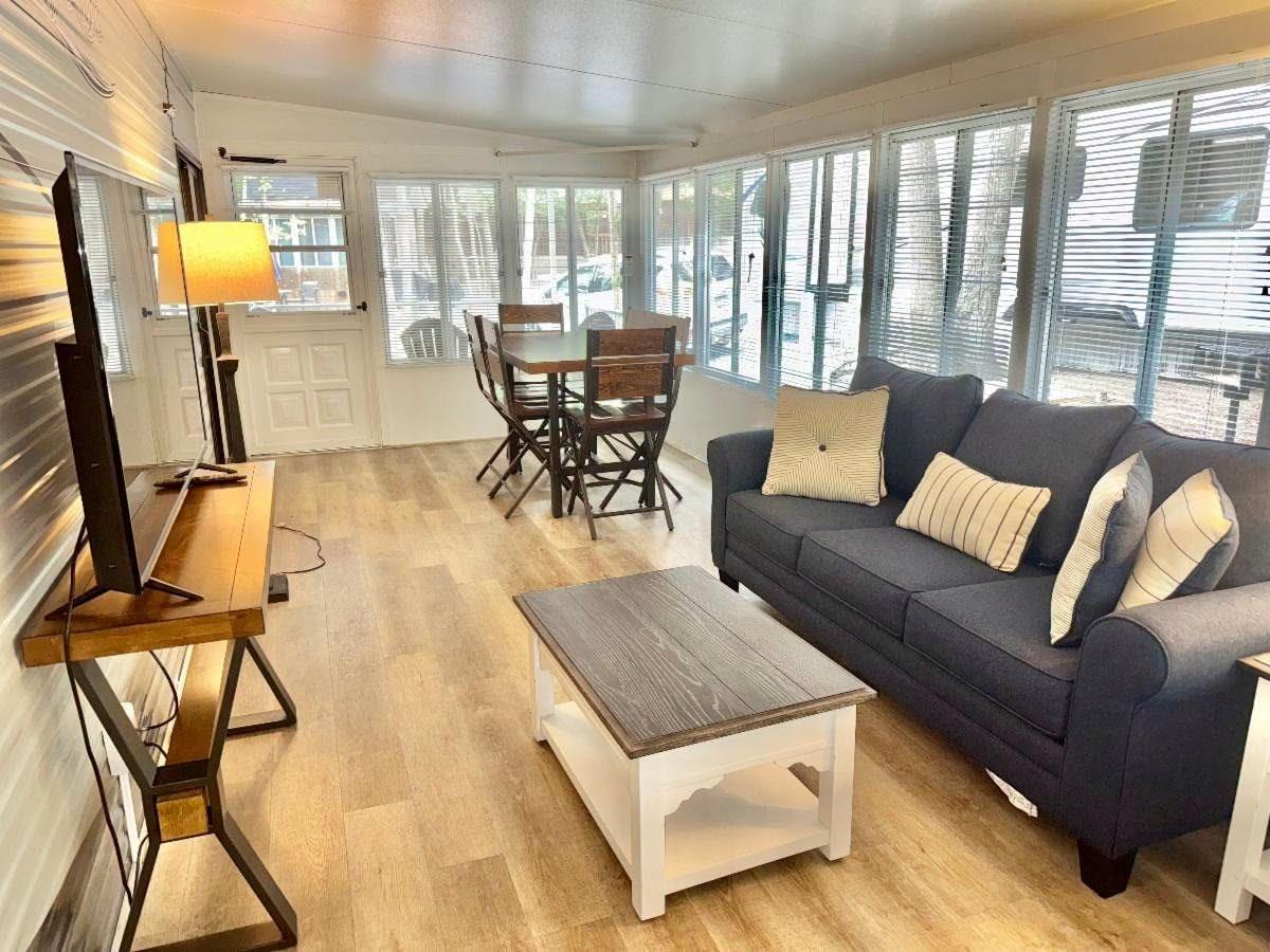Florida room living area with a sofa, dining set, and a wall of windows