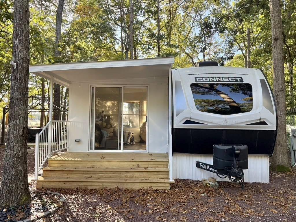 Enclosed Florida room with a wood deck attached to a travel trailer